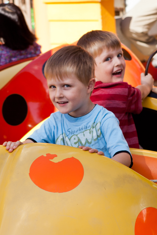 Andrew and Will riding the ladybugs at Happy Hollow