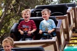 Will and Andrew riding the roller coaster at Happy Hollow