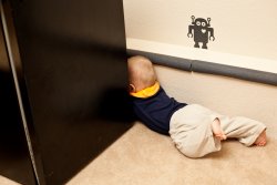 Andrew tries to squeeze behind the mini-fridge